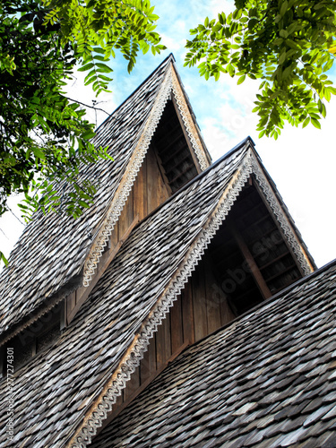 close up traditional asian roof top of building with wooden roof tiles in Phuket island, Thailand photo