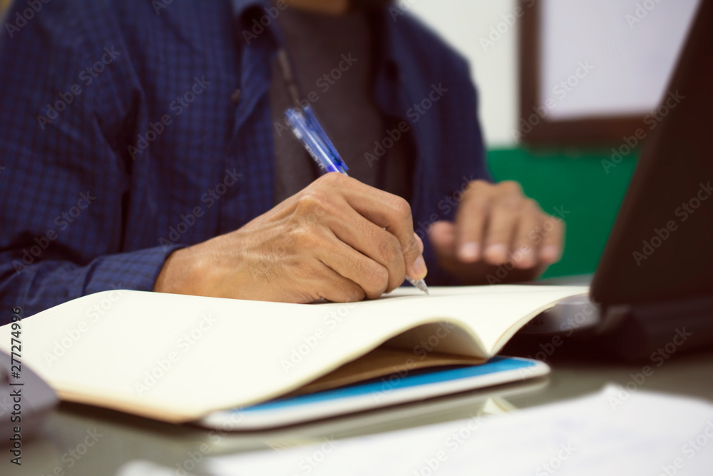 Businessman write on book work in office Businessman write on book work in office