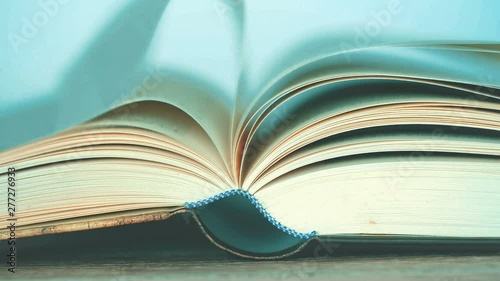 close up opened book on the table , wind turning the book page ,reading textbook or  learning education concept