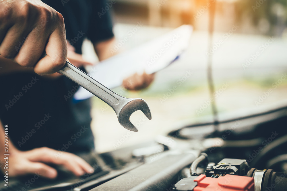 Fototapeta premium Car mechanic is holding a wrench ready to check the engine and maintenance.