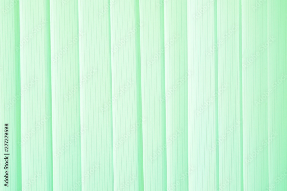 Obraz premium Green ribbons closed the vertical window blinds. Abstract background, seamless texture. Horizontal frame