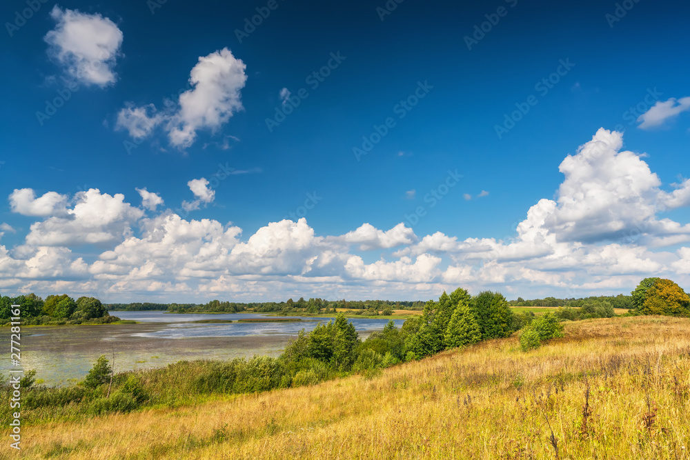 Clouds above the lake in a countryside at summer day