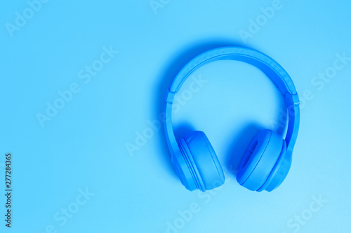 blue headphones, Top view of headphones on blue background. Minimalist photo of earphones with copy space. White dj headphones, Top view blue headphones on blue background