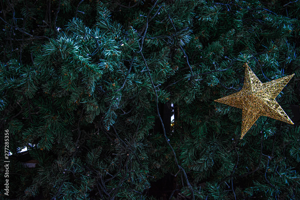 Decoration of  Christmas tree with  hanging golden star.