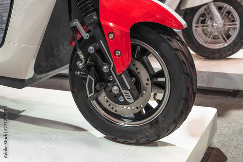 Close-up of electric motorcycle wheel and disc brake system on the auto show stand