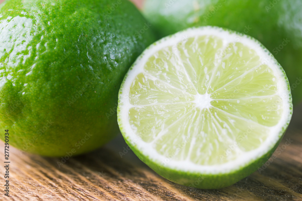 Fruit lime with lime slices over wooden background. Citrus fruit. Fruit lime with lime slices over wooden background. Citrus fruit.
