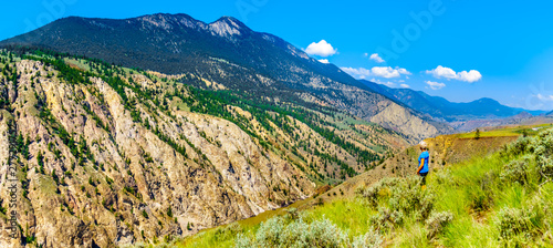 Woman enjoying the panorama view of the Fraser River along Highway 99, from the 10 mile slide or Fountain Slide area, as the river flows to Lillooet in the Chilcotin region on British Columbia, Canada photo