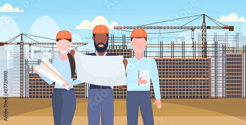 architects working with blueprints mix race engineers team discussing new building project during meeting builders in helmet teamwork concept construction site background portrait horizontal
