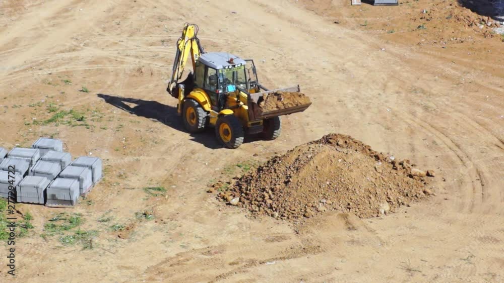 Tractor digs the land, preparing the area for construction. Plot for the construction of the house. General view. Tractor digs the land, preparing the area for construction. Plot for the construction of the house. General view.