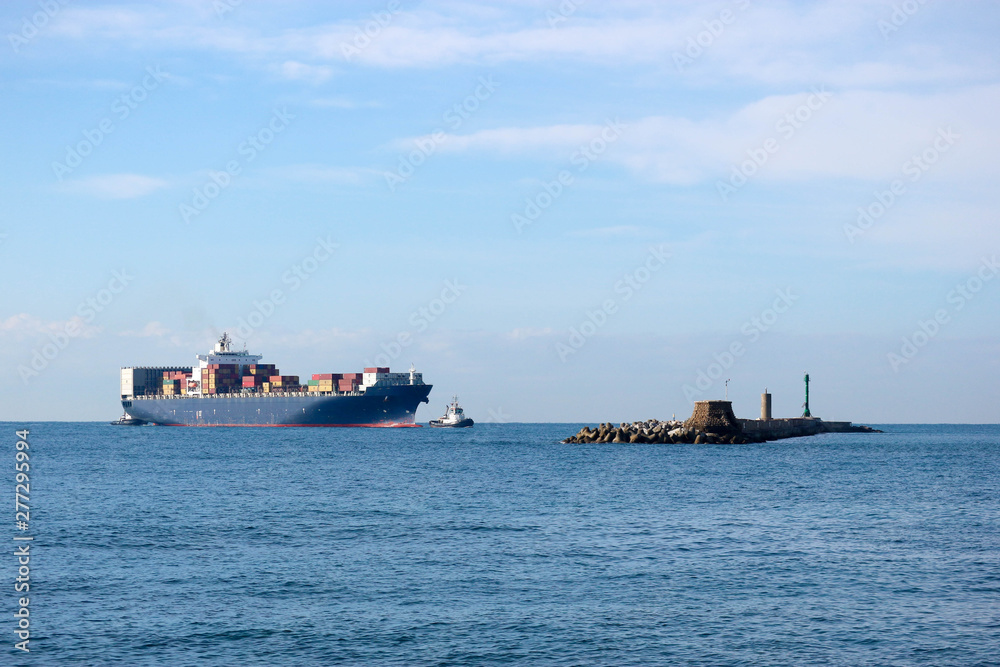 Large container ship with a tugboat near the Livorno port, Italy