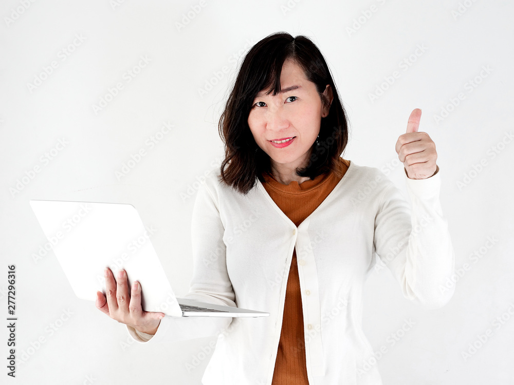 Thumbs up happy Asian woman using laptop against the wall, lifestyle concept. Thumbs up happy Asian woman using laptop against the wall, lifestyle concept.