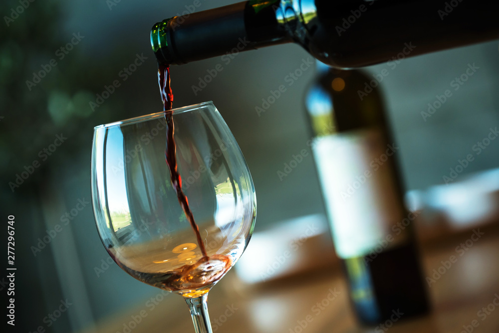 Pouring red wine on a wooden oak table