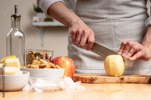The chef prepares a vegetarian salad with the hand of a chef in the home kitchen. Light background with text area for restaurant menu design. The concept of healthy eating, cooking salad