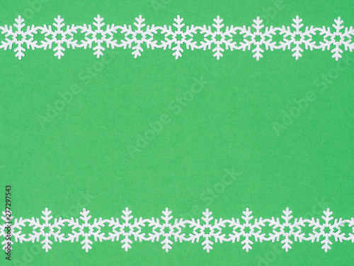 White laces snowflake on green background. Christmas and New year concept