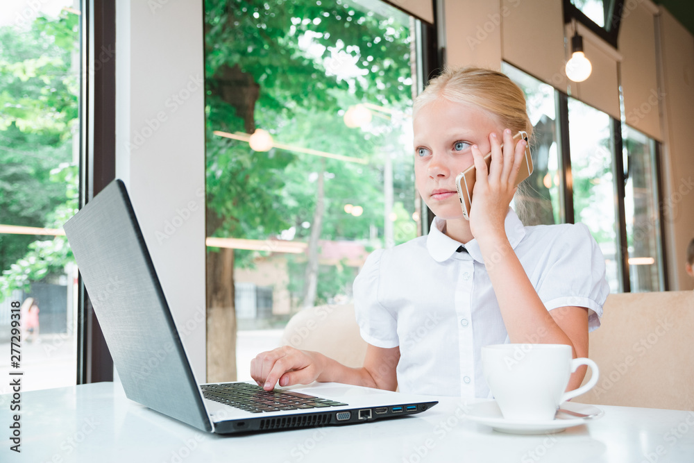 Portrait of child behind a laptop in cafe. Internet and telephone communications. Portrait of child behind a laptop in cafe. Internet and telephone communications.