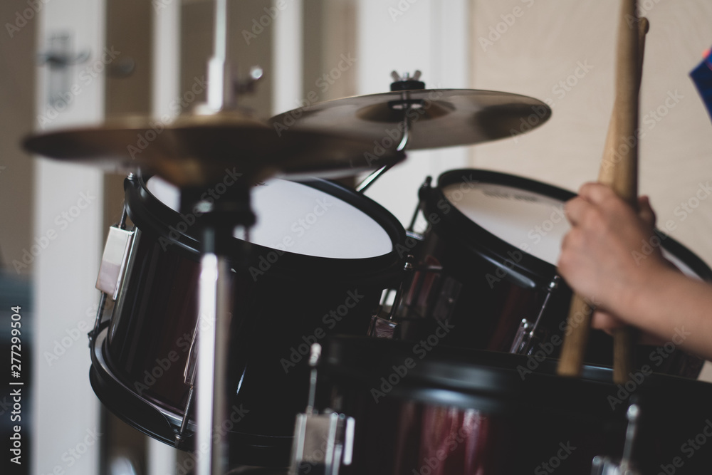 Child's drum set with visible drumsticks and hands. 