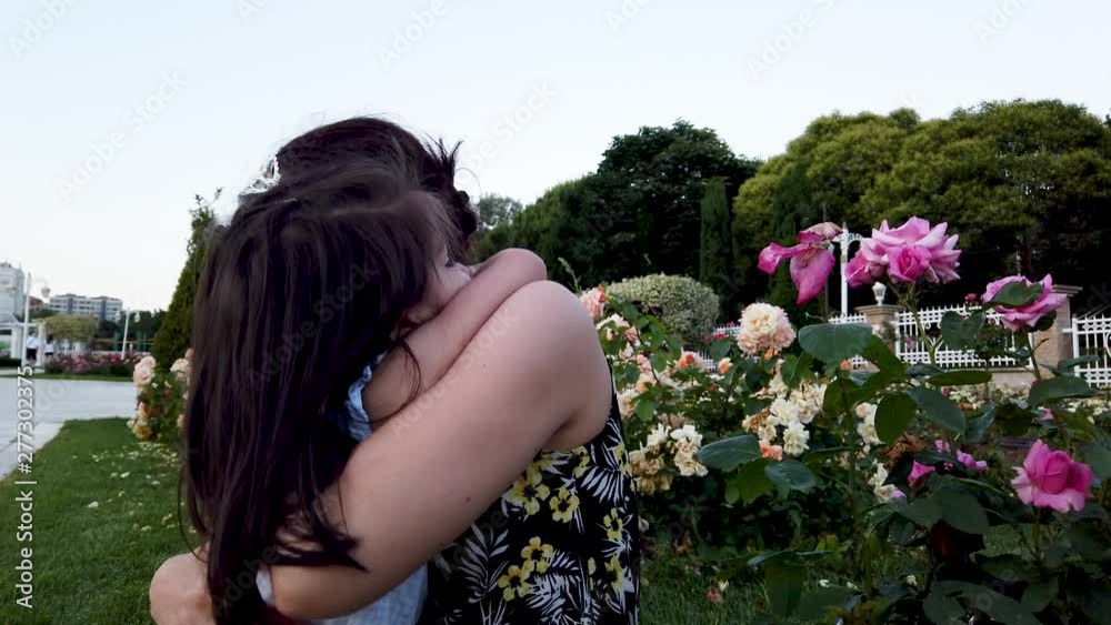 Mother and daughter hug together and have fun in park Mother and daughter hug together and have fun in park