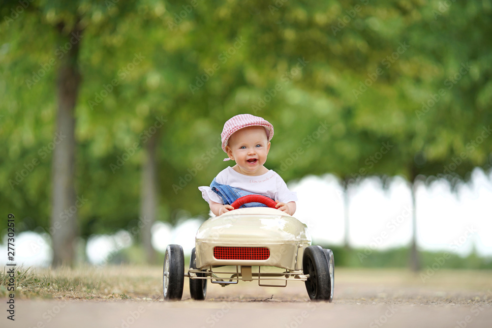 happy little girl in toy car - summer day in park happy little girl in toy car - summer day in park