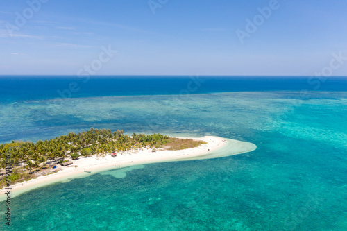 Tropical island Canimeran with sandy beach in the blue sea with coral reef, top view. Balabac, Palawan, Philippines. Small island with palm trees and white sand.