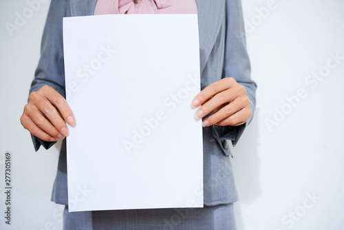 Cropped image of female entrepreneur holding blank white paper sheet photo