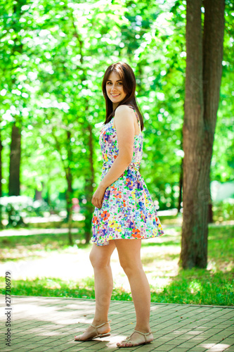 Young beautiful woman in dress in the summer park