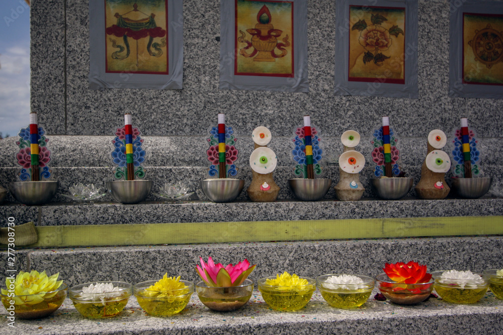 Thangka, essential oil plates, flowers, offerings on a granite Buddhist stupa