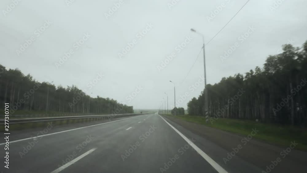 View on highway through wet windshield. Drive in rainy day. View on highway through wet windshield. Drive in rainy day.