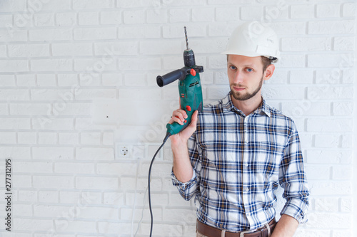 portrait of a constructor holding a drill