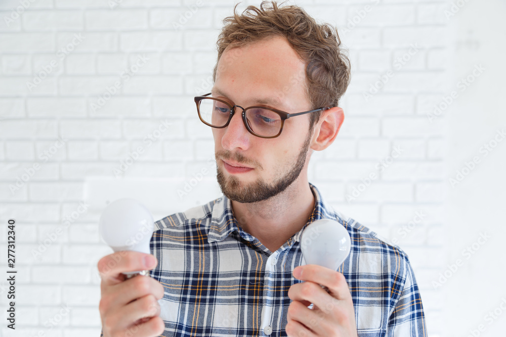 Man holding incandescent and LED lamps. An offering of two different light bulbs. Energy efficiency concept Man holding incandescent and LED lamps. An offering of two different light bulbs. Energy efficiency concept