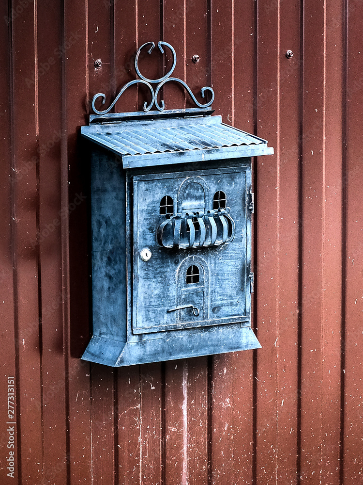 Mailbox in the form of an old house on the gate 
