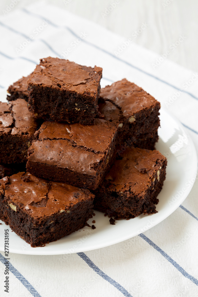 Homemade chocolate brownies on a white plate, low angle view. Closeup. Homemade chocolate brownies on a white plate, low angle view. Closeup.