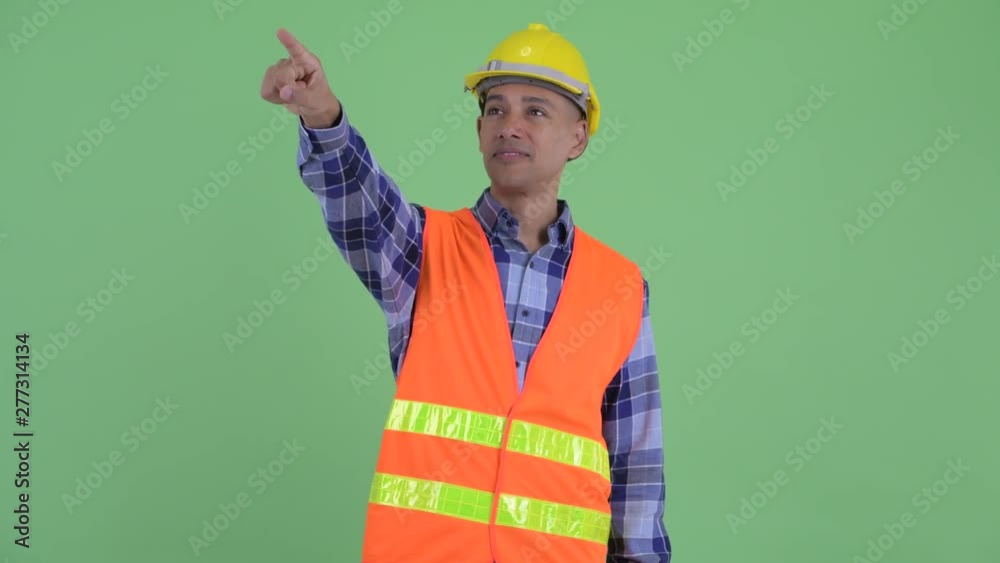 Happy multi ethnic man construction worker pointing finger Happy multi ethnic man construction worker pointing finger