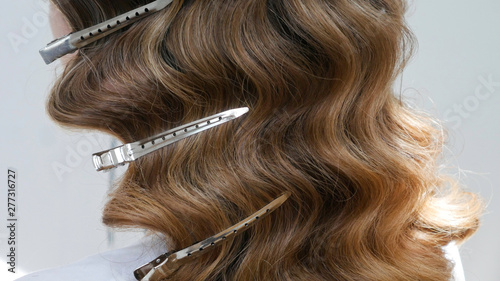 Silver hairdressers clips in wavy hair - close up 