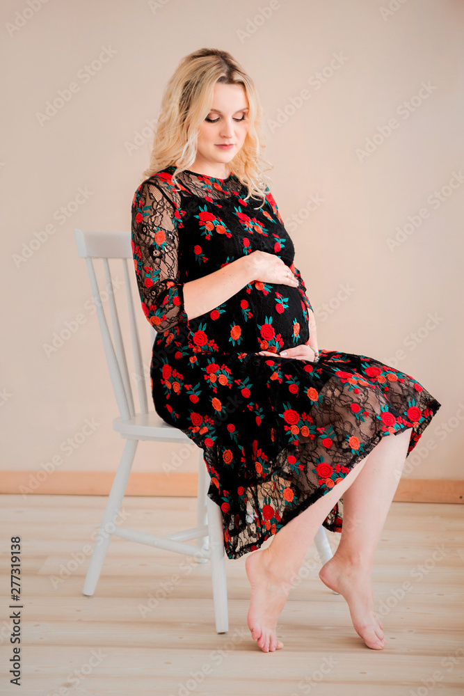 Pregnant woman sitting on a chair Stock Photo