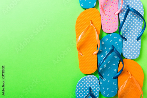 Fotografía a lot of flip flop colored sandals, summer vacation on colored background, copy