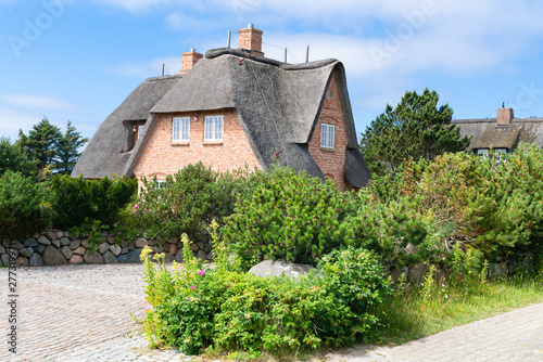 Typical house with straw roof in small village on Sylt island, Germany. photo