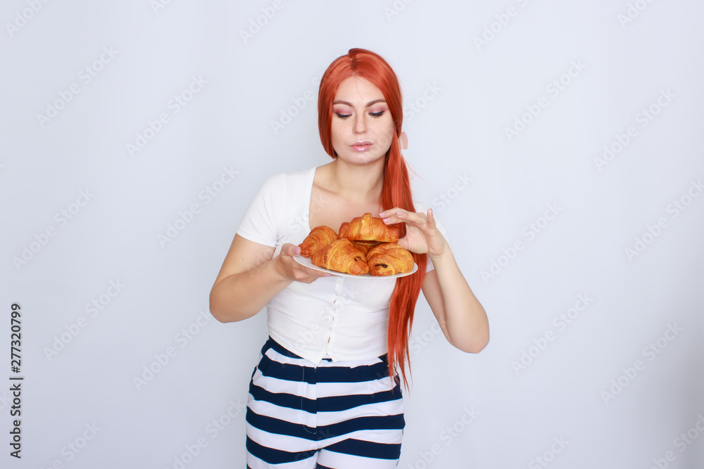 Red haired woman holding plate with croissants Red haired woman holding plate with croissants