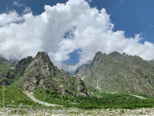 Russia, North Ossetia - Alania. The tops of the mountains framing Tsey (Tseyskoe, Tseyskoye) gorge in sunny June day photo