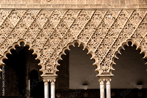 Fototapeta Arches and columns from the Real Alcazar of Sevilla, Spain with intricate hand carved geometric patterns