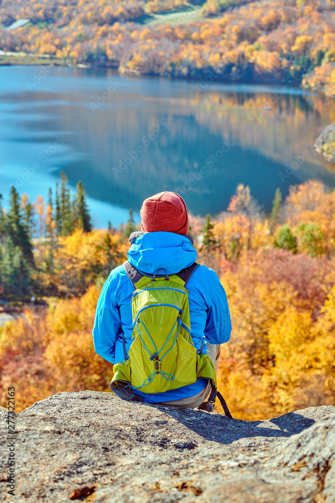 Backpacker man hiking at Artist's Bluff in autumn. Fall colours in Franconia Notch State Park. White Mountain National Forest, New Hampshire, USA Backpacker man hiking at Artist's Bluff in autumn. Fall colours in Franconia Notch State Park. White Mountain National Forest, New Hampshire, USA