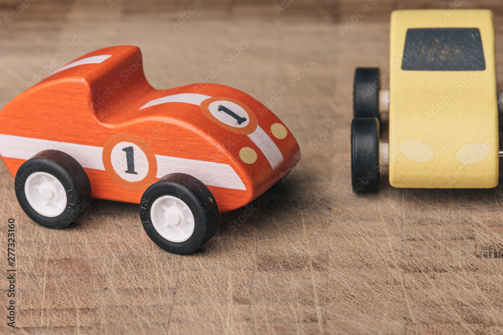 Red and yellow toy car on a wooden surface Red and yellow toy car on a wooden surface