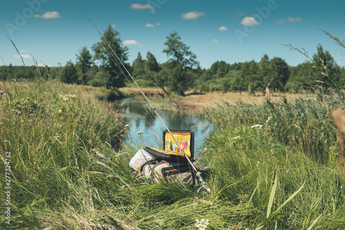 Wallpaper Mural Bag with fishing essentials at riverside on sunny day Torontodigital.ca