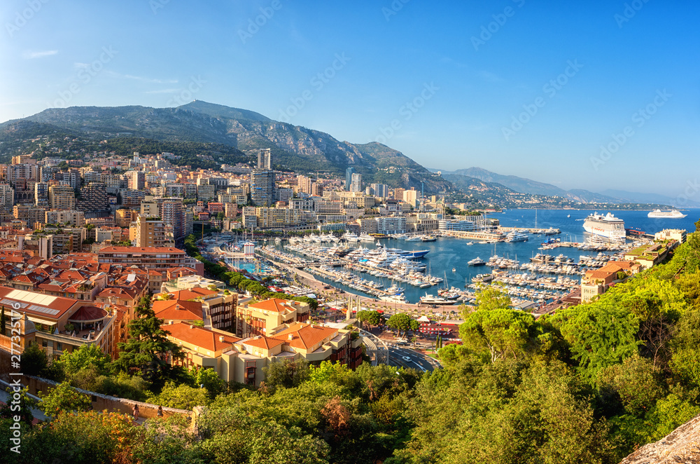 Panoramic view of Monaco harbor, Monte Carlo. Scenic summer cityscape with buildings, mountains, luxury yachts and blue sky, Cote d'Azur, microstate of the French Riviera, outdoor travel background