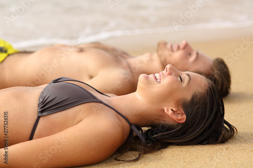 Photography Happy sunbathers sunbathing on the sand of the beach