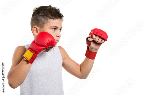 karate boy in fighting stance concentrates on his hands red gloves, on a white background