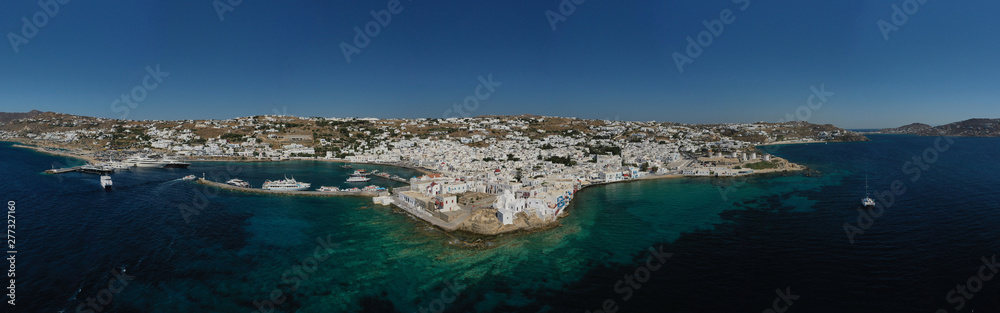 Aerial drone photo of popular landmark chapel of Paraportiani with beautiful emerald colour rocky seascape next to little Venice, main town of Mykonos island, Cyclades, Greece