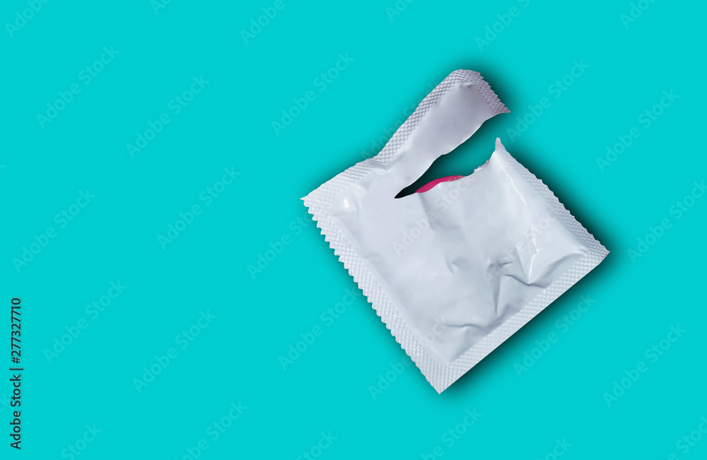 Condom on a wooden floor background. Flat view, from above. The concept of safe sex.