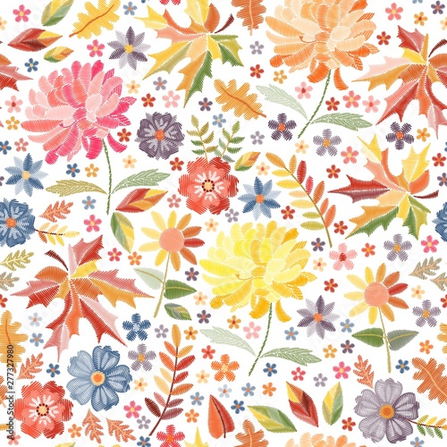 Bright embroidery with autumn flowers and leaves on white background. Colorful seamless pattern with embroidered print.