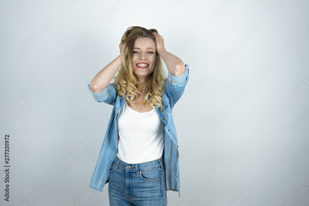 blonde girl holding hands near head looks surprised white isolated background blonde girl holding hands near head looks surprised white isolated background