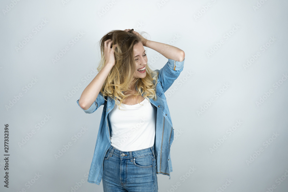 blonde girl holding hands near head looks surprised smiling white isolated background blonde girl holding hands near head looks surprised smiling white isolated background